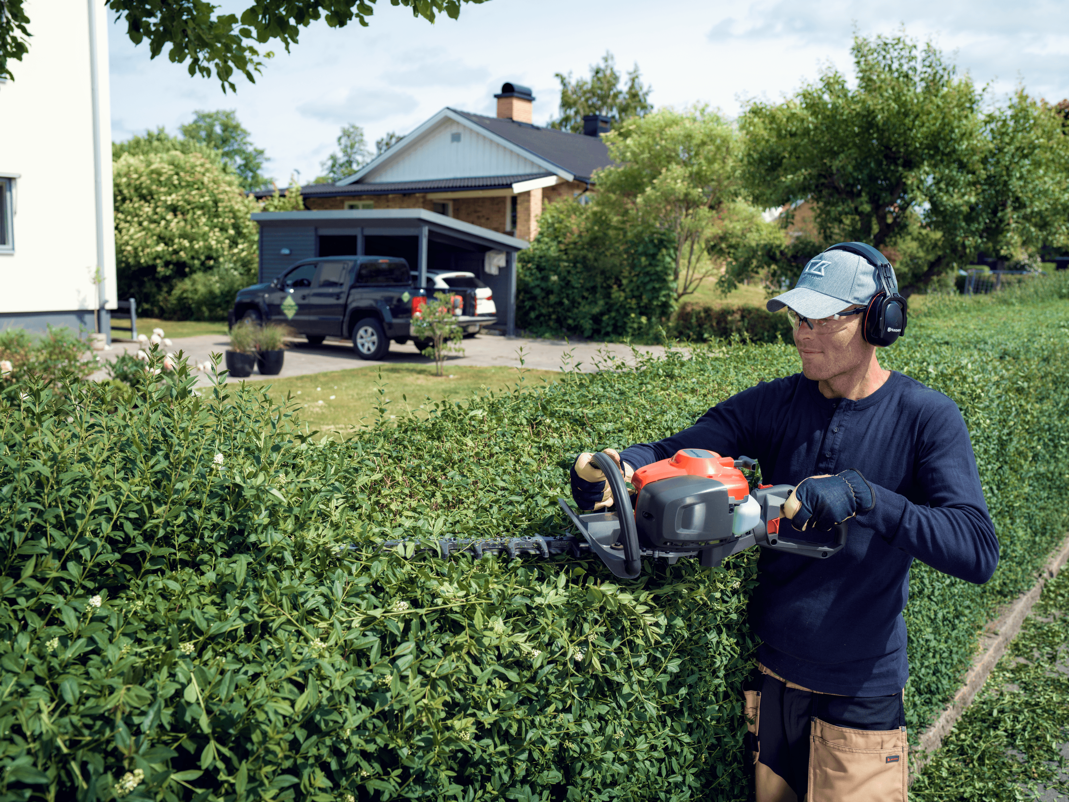man holding chainsaw whilst cutting tree
